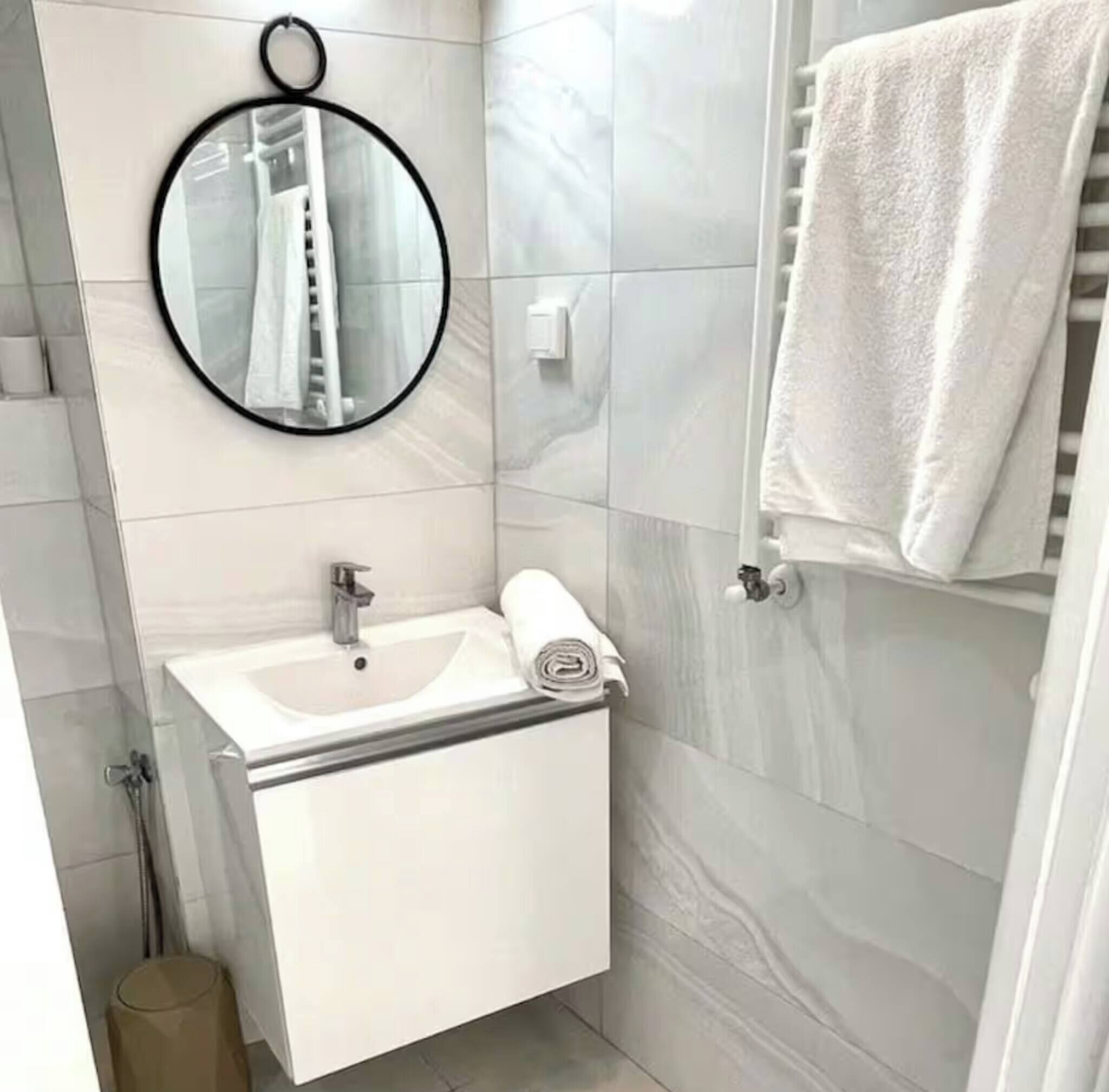 Ein modernes Badezimmer mit Waschbecken, Spiegel und Handtuchhalter.