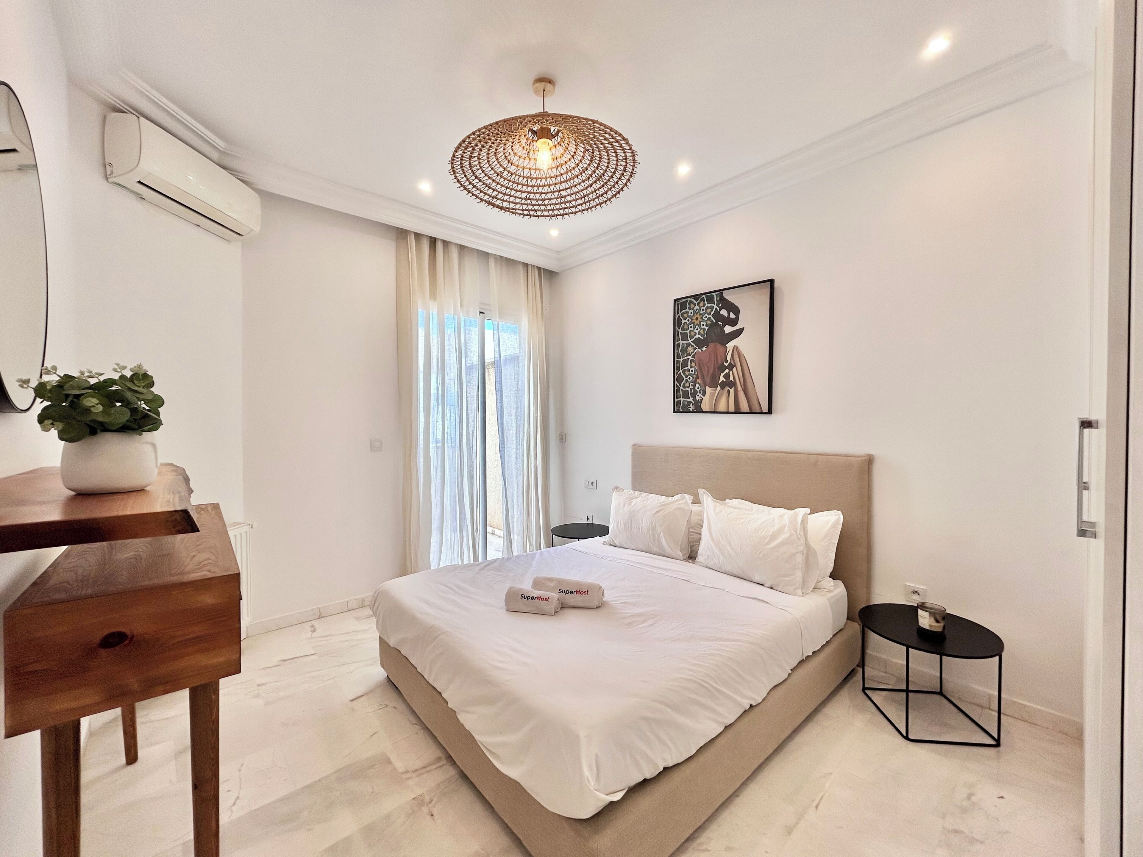 A modern bedroom with a bed, bedside table, and a small side table.