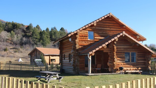 A log cabin with a porch, a picnic table, and a barbecue grill. - Le chalet neige – Chorges Hautes-Alpes (Chorges)