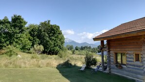 A log cabin with a patio, surrounded by trees and mountains. - Le chalet neige – Chorges Hautes-Alpes (Chorges)