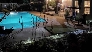 A swimming pool with a covered seating area and lounge chairs. - 4-bedroom house in adorable Pinehurst with cozy living spaces (Pinehurst)