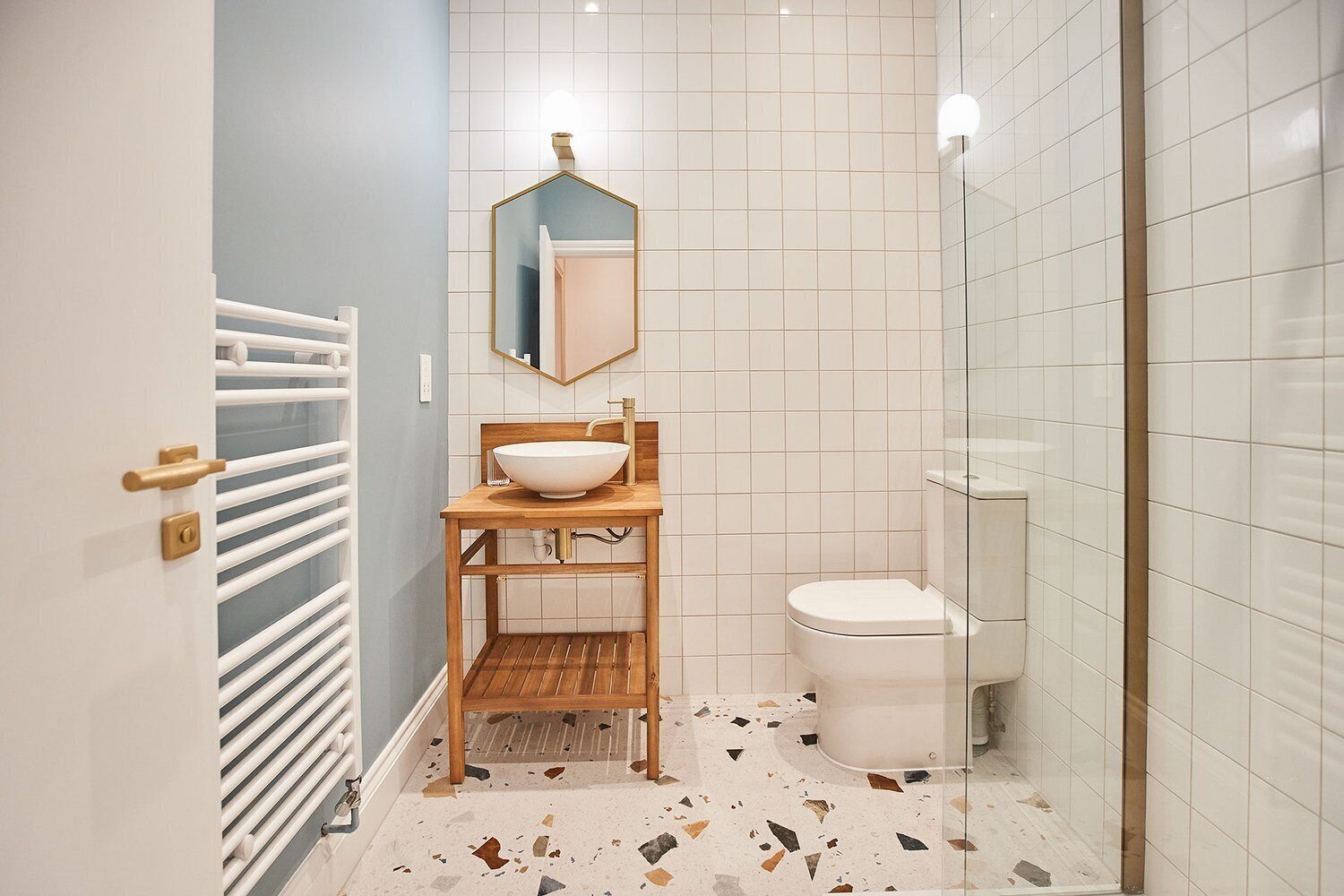 Une petite salle de bain avec un lavabo blanc, un miroir et des toilettes.