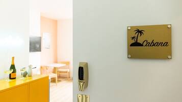 Habitación de hotel con una nevera minibar amarilla, un lector de llavecard montado en la pared y un cartel que dice 'Cabana'.