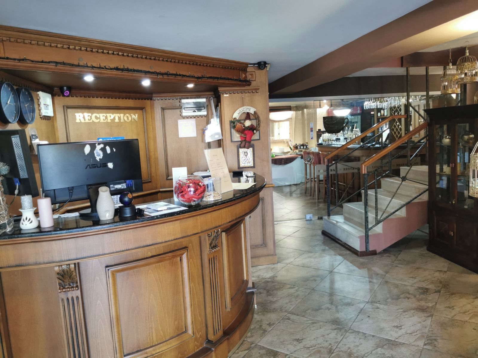 A reception area with a wooden counter, a television, and a sign that reads 'RECEPTION'.