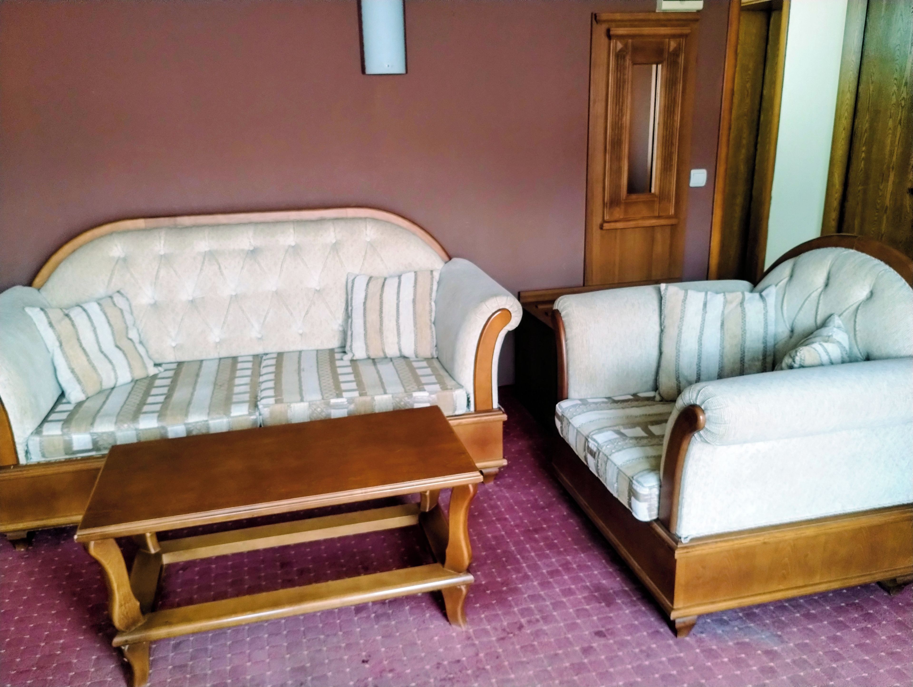 A living room with a sofa, armchair, and coffee table.