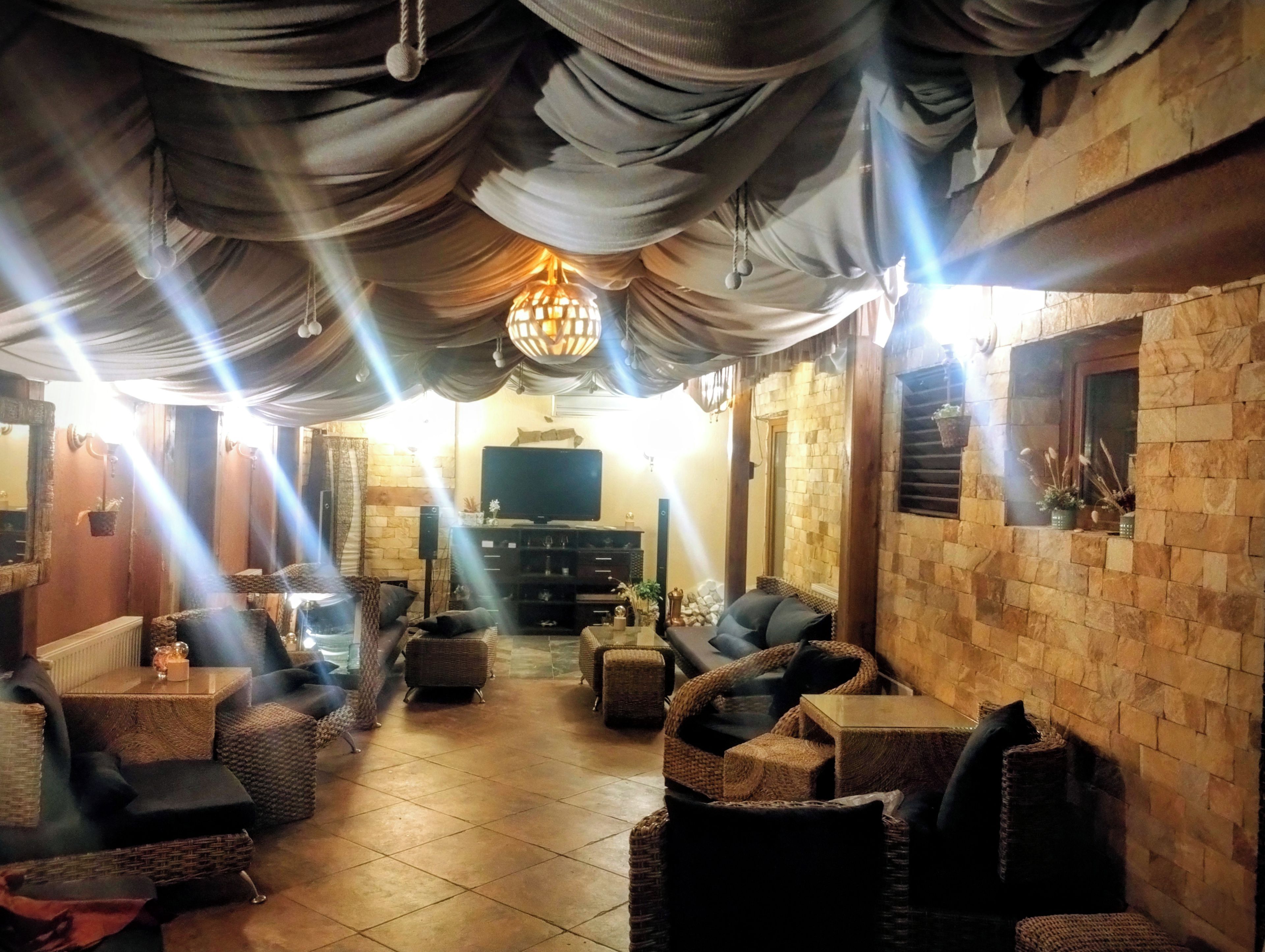Una sala de estar acogedora con mobiliario de mimbre, un televisor de pantalla plana y una pared de piedra.