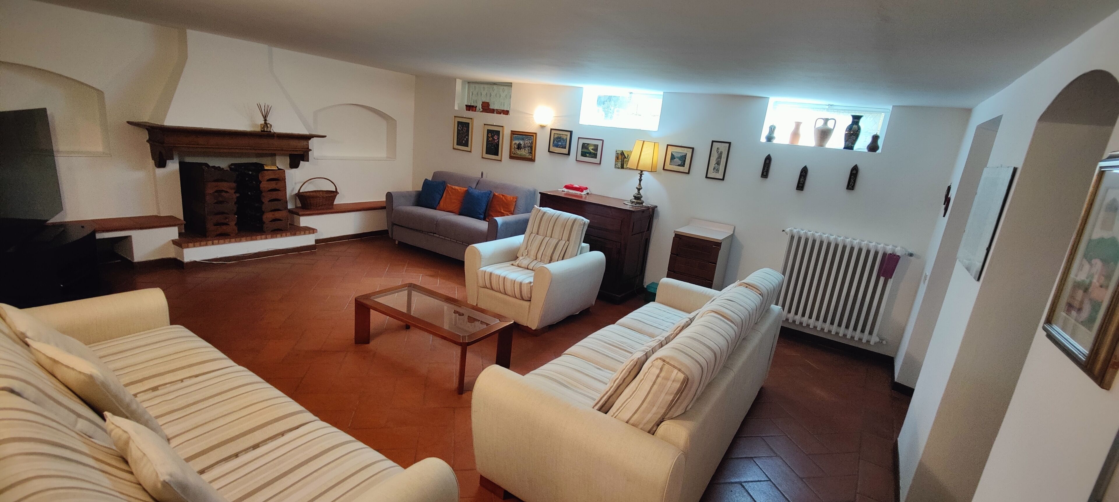 A living room with a fireplace, sofas, a coffee table, and a radiator.
