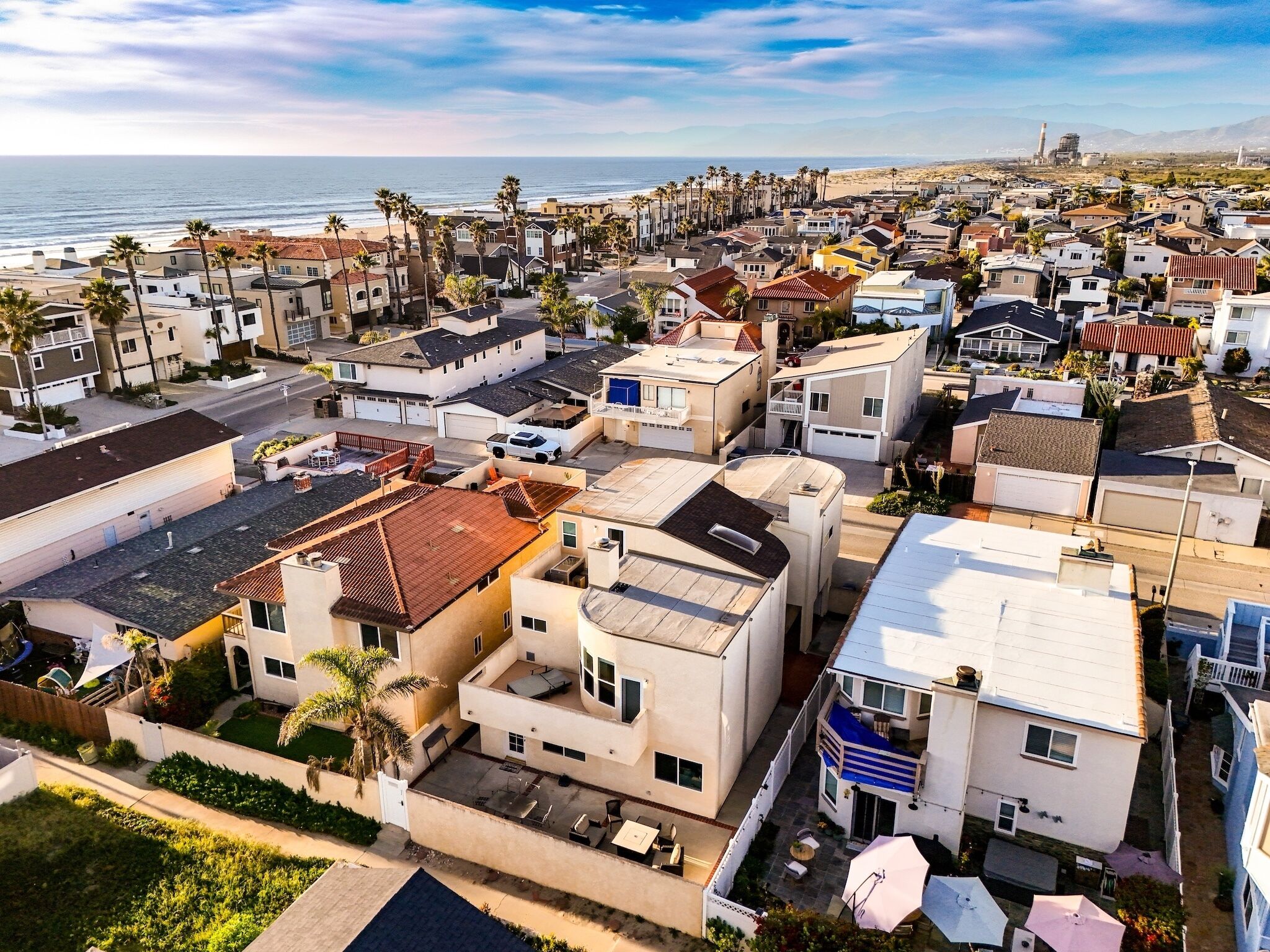 A residential area with houses, some with balconies, and a view of the ocean.