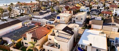 A residential area with houses, some with balconies, and a view of the ocean.
