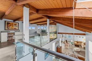 Un loft espacioso con techos altos, un balcón de vidrio y un interior moderno.