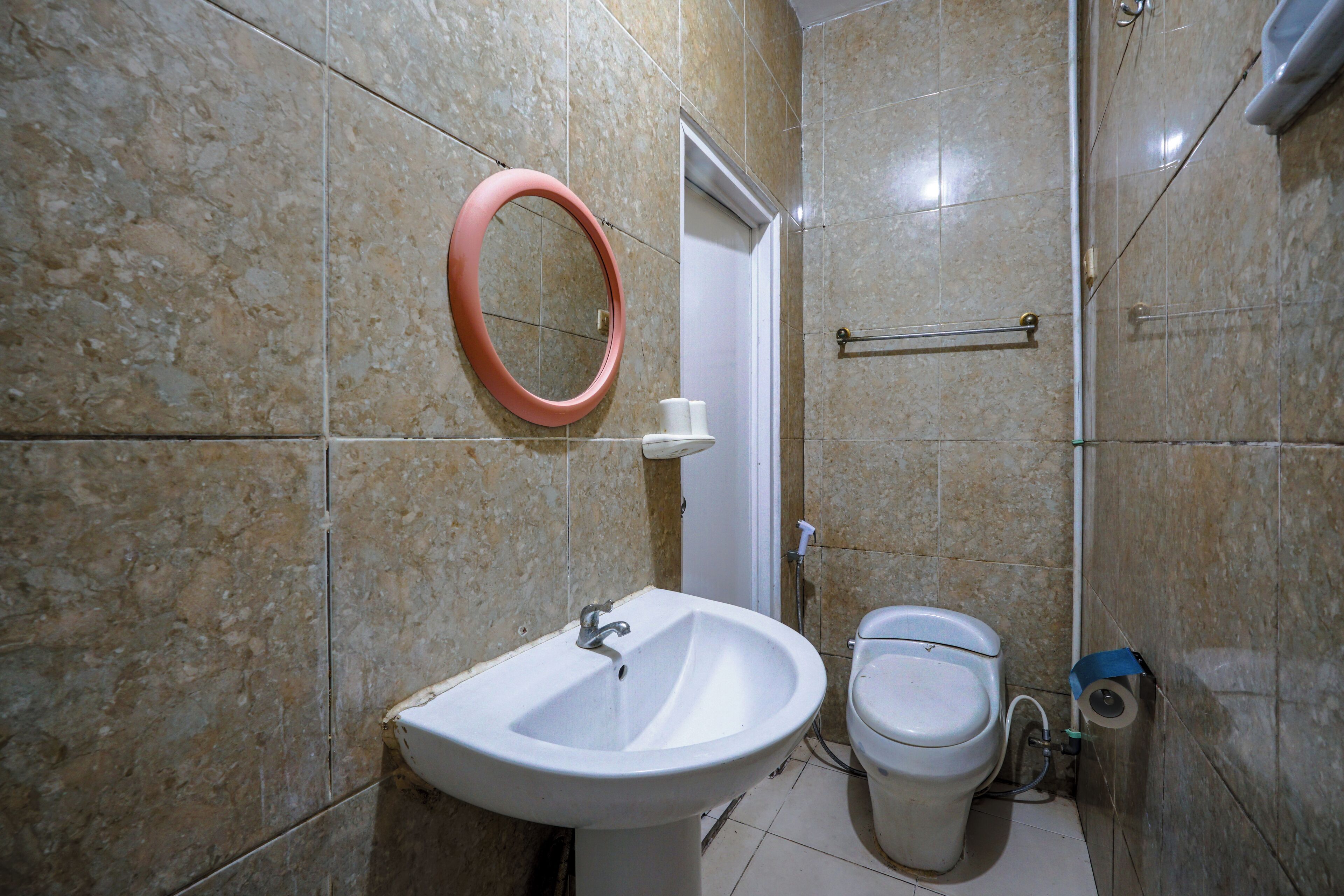 Baño con lavamanos, inodoro y espejo.