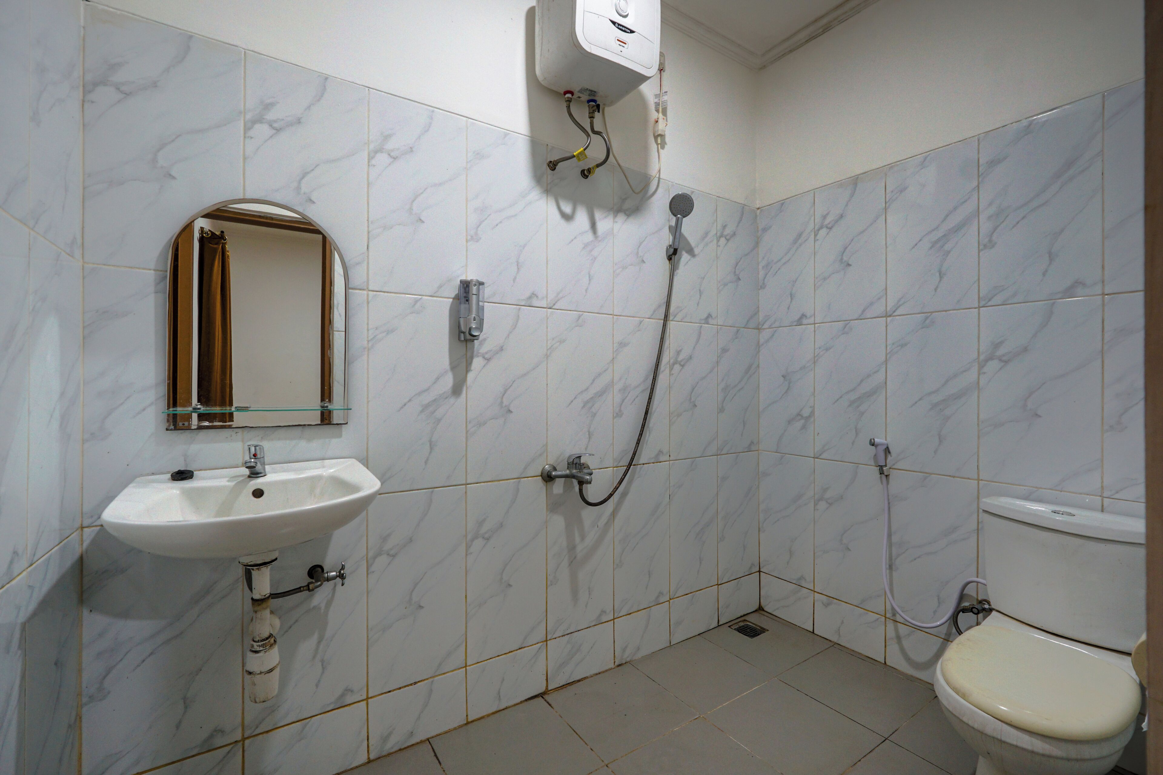 A bathroom with a white sink, a mirror, a toilet, and a shower.