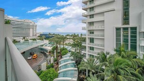 A modern hotel with multiple floors, large windows, and a view of the ocean. - Fontainebleau Jr. Suite Tresor just Renovated (Miami Beach)