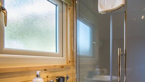 A bathroom with a glass shower enclosure, a sink with a soap dispenser, and a window above the sink. - Cosy Eco Cabin with stunning views (Glencoe)