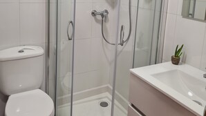 A modern bathroom with a glass-enclosed shower, a white toilet, and a sink with a mirror. - Apartment near Padrón and Camino Portugués 5 (Pontecesures)