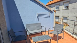 A balcony with a blue wall, a metal bench, and two metal chairs. - Apartment near Padrón and Camino Portugués 5 (Pontecesures)