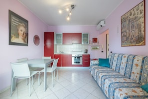 A compact living space with a kitchenette, a dining area, and a sofa. - Happy Tourist by Wonderful Italy (Sanremo)