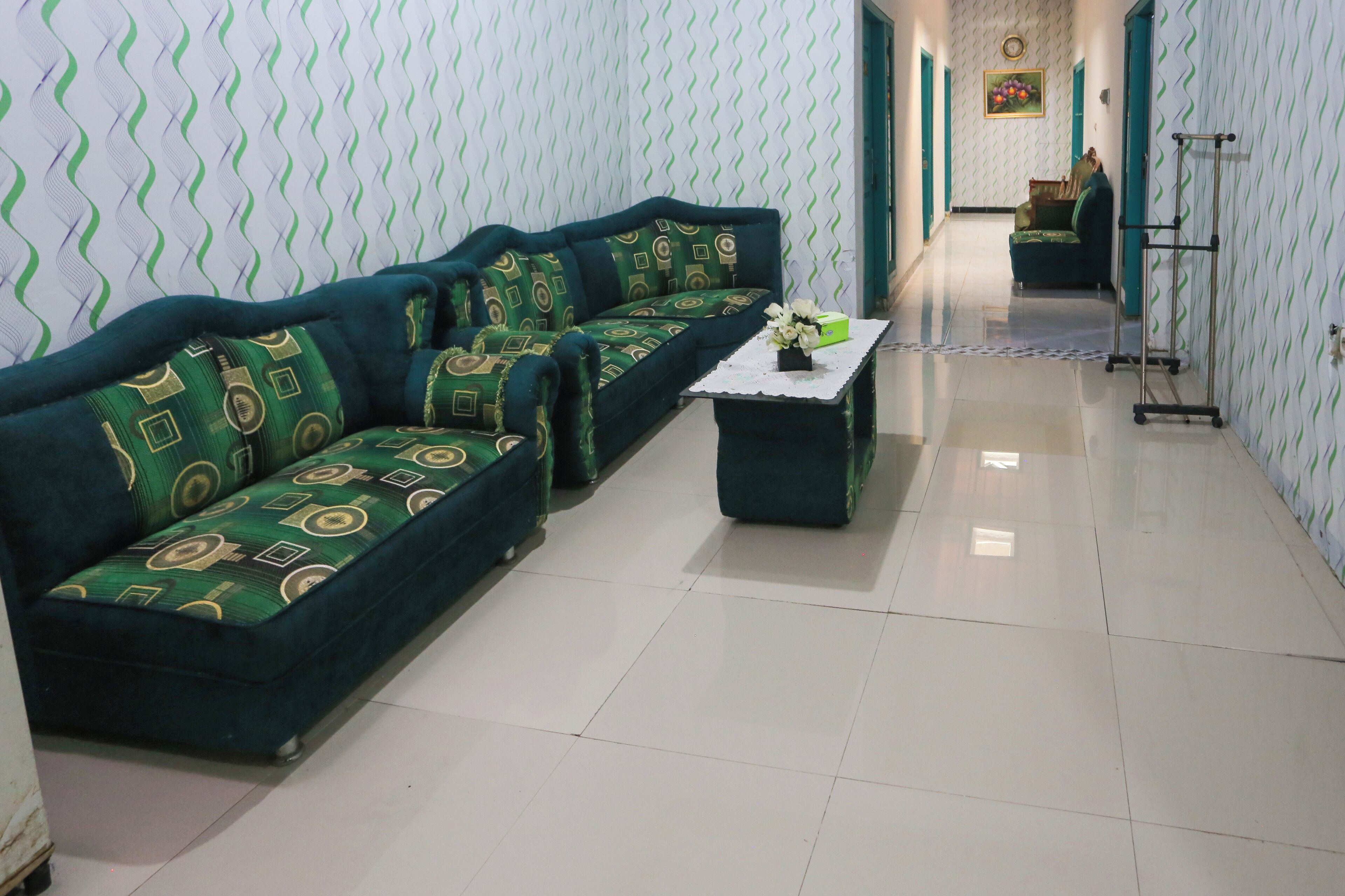 A living room with a sofa set, a coffee table, and a patterned wall.