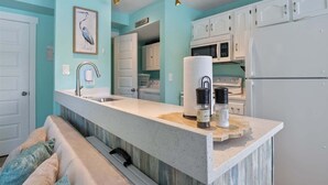 A kitchen with a central island, white cabinets, and a teal wall. - Lakeside Serenity Dock Days & Firepit Nights (Gravois Mills)