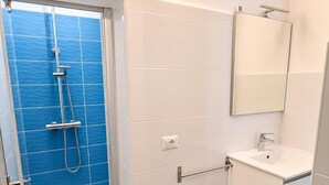 A bathroom with a shower, toilet, sink, and mirror. - Casa Patavina (Padova)