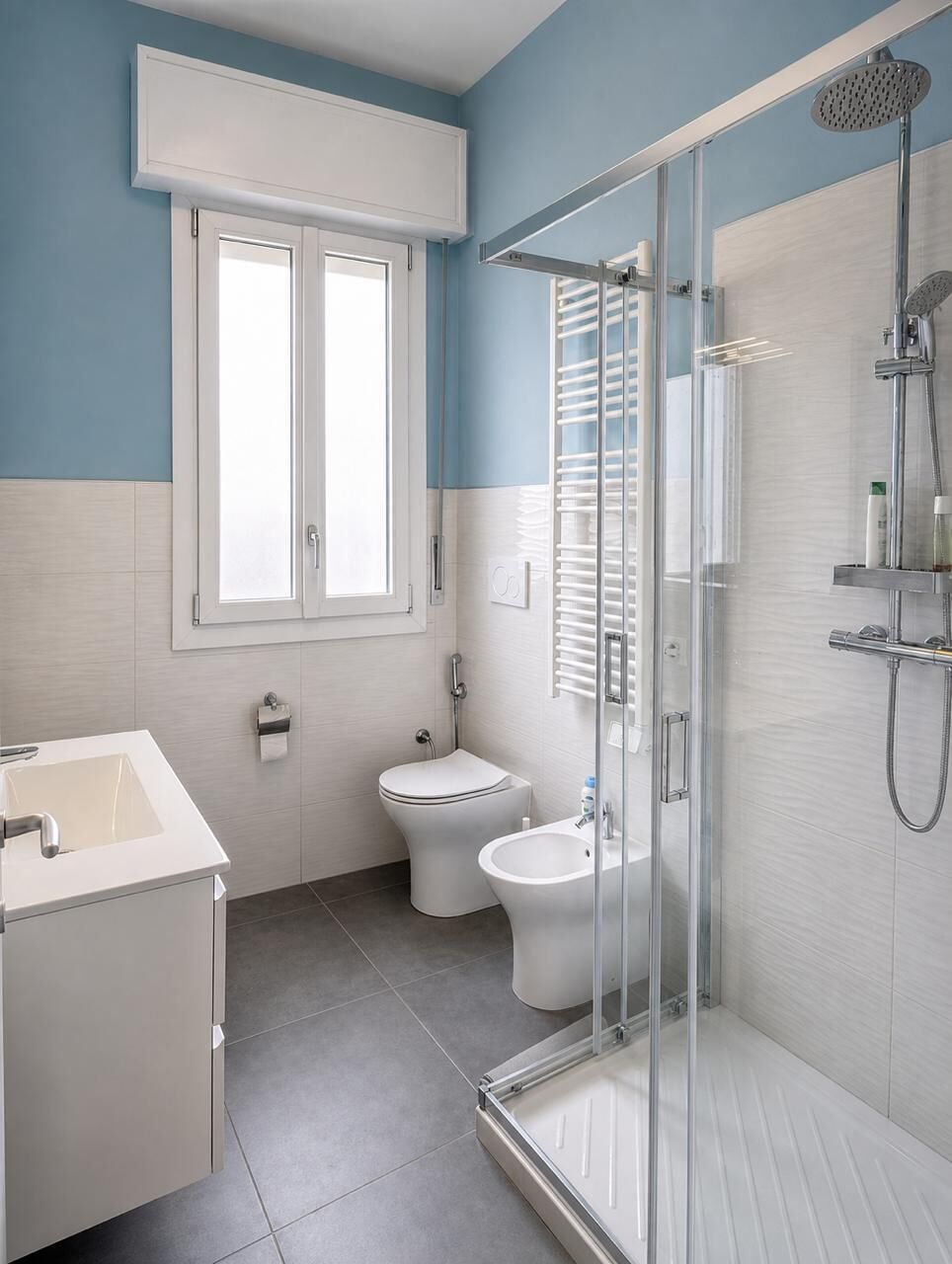 A bathroom with a shower, toilet, and sink.