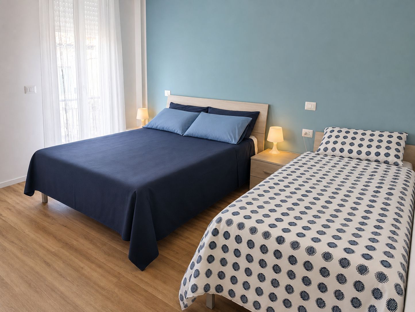 Een slaapkamer met een bed, nachtkastje en lamp.