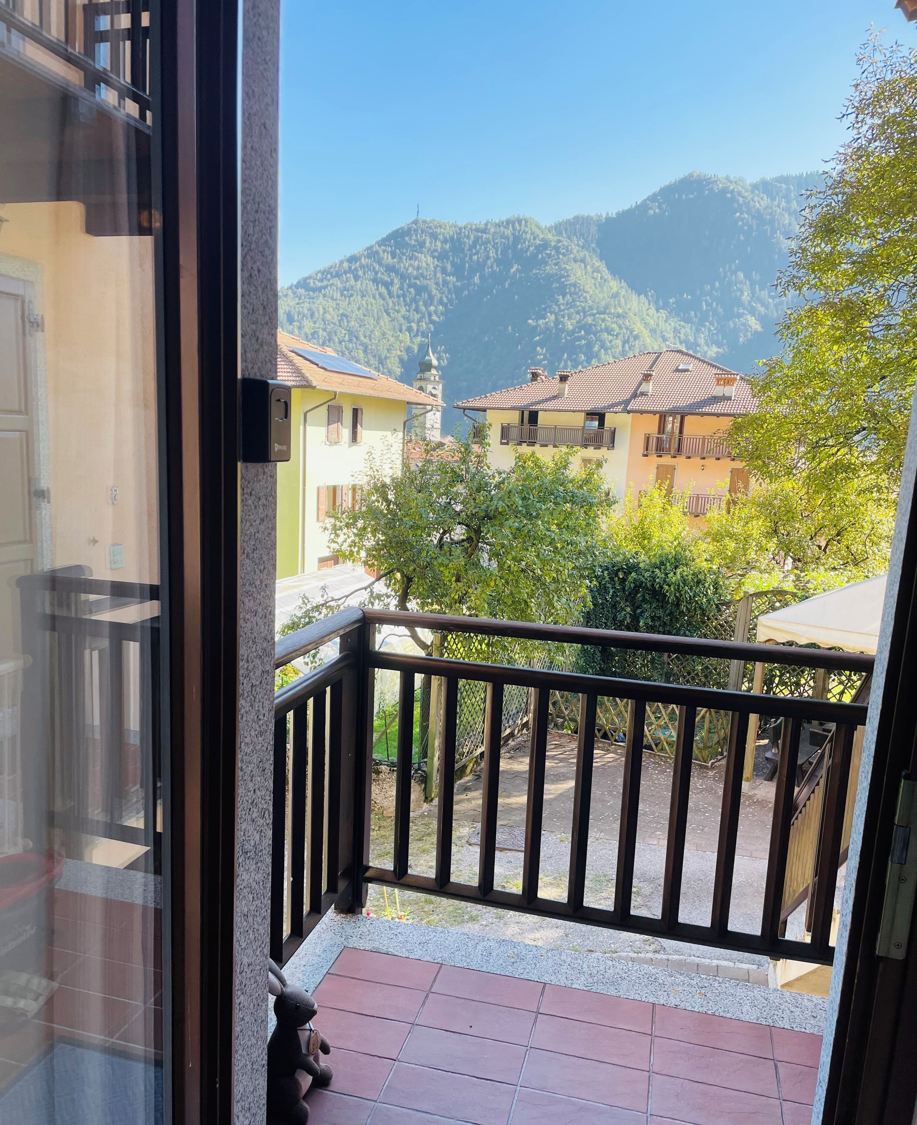 A balcony with a view of a mountain and houses.