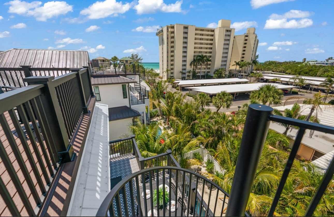 Un hotel con varios pisos, zonas de estar al aire libre y vistas al océano.