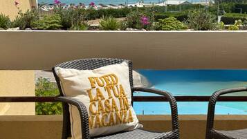 A wicker chair with a cushion that reads 'FUEO LA TUA CASA IN VACANZA.'