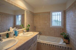 A bathroom with two sinks, a bathtub, a large mirror, and a window. - La Maison des Restanques (Cabrières-d'Avignon)