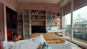 Ein modernes Wohnzimmer mit einer Couch, einem Fernseher und einem Bücherregal.