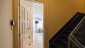 A hallway with a door leading to a dining area and a staircase. - Downtown Formosa Studio by Vacationy (Porto)