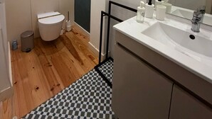 A modern bathroom with a toilet, sink, and mirror. - Marques 1243 Studio by Vacationy (Porto)
