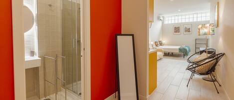 A modern bathroom with a glass shower enclosure, a white sink, and a large mirror.