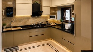 A modern kitchen with a built-in stove, microwave, and water dispenser. - Cascade Villa Spacious 5BHK Luxury Villa (Bengaluru)