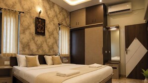 A bedroom with a bed, curtains, a wall-mounted picture, a wardrobe, and an air conditioning unit. - Cascade Villa Spacious 5BHK Luxury Villa (Bengaluru)