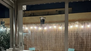 Um quarto com um aquecedor branco, uma mesa pequena, duas cadeiras e uma planta cacto.