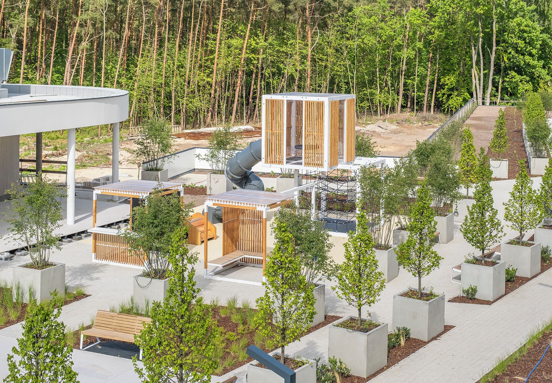 A modern outdoor area with seating, a telescope, and a forested background.