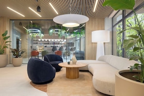 A modern lounge area with seating, a bar, and a view of the outdoors. - Essense Baltic Resort & SPA (Dziwnów)