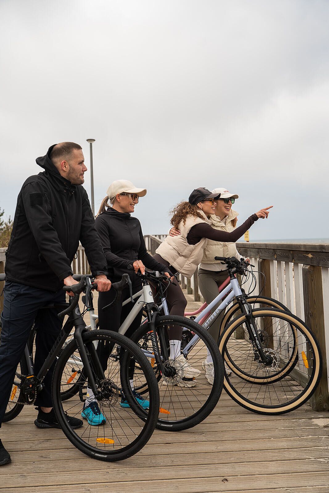 A group of people on bicycles on a wooden deck with a railing.
