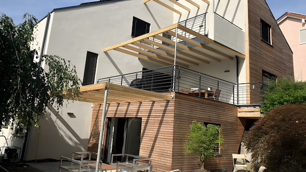 A modern multi-story building with a balcony, outdoor seating, and a potted plant. - Modern Feel-Good Apartment in Marbach am Neckar Near Schillerhöhe (Marbach am Neckar)