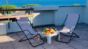 A terrace with two chairs, a small table with fruit, and a view of the sea. - Attico del Sole con Vista Mare e Terrazza (Marina di Andora)