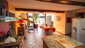 A kitchen with a dining area, a staircase, and a view of the outdoors. - Charming renovated farmhouse with river and forest area (Orgueil)