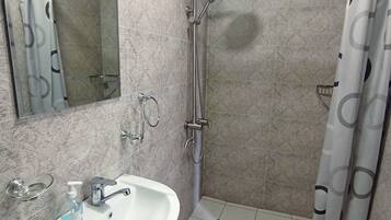 Habitación triple, vistas al jardín | Baño | Ducha, zapatillas, toallas y jabón