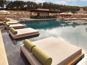 A poolside area with lounge chairs and a bar. - Mangia's Costa Ragusa Borgo - New Opening (Scoglitti)