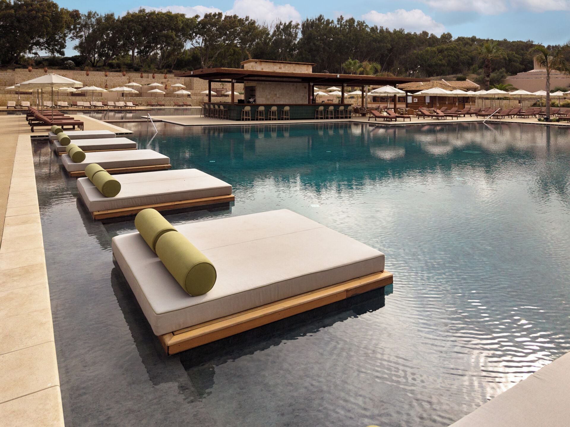 A pool with lounge chairs and umbrellas.
