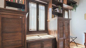 A room with a built-in bench, wooden cabinets, and a bookshelf. - Apartments Florence - Nido Fiorentino (Florence)