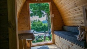 Un accogliente chalet in legno con tetto curvo, una panca e un tavolo all'esterno.