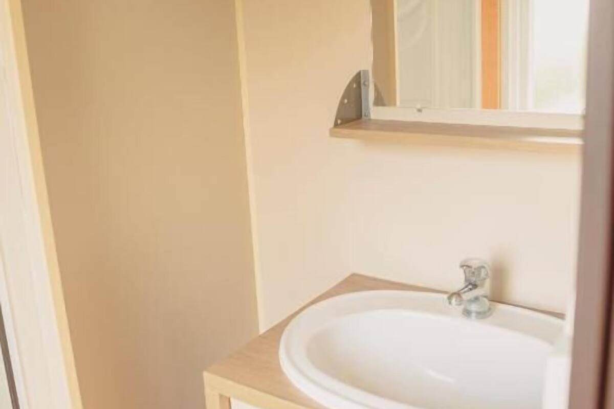 Ein Badezimmer mit Waschbecken, Spiegel und Holzschränken.