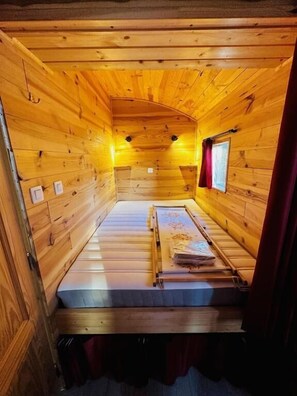 A small, cozy cabin room with wooden walls and a single bed. - Camping Le Pommier Rustique (Yvoir)